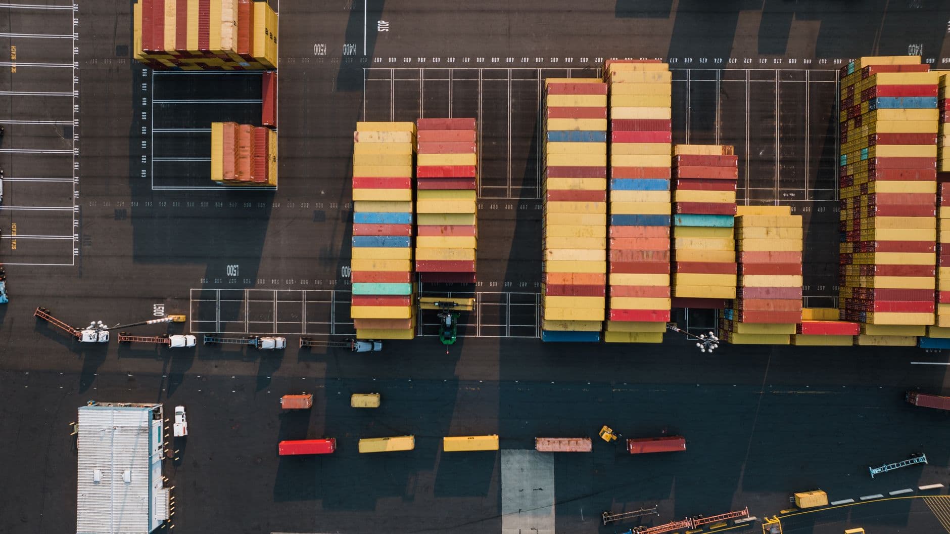 High-angle view of colorful shipping containers stacked at a Seattle port yard.