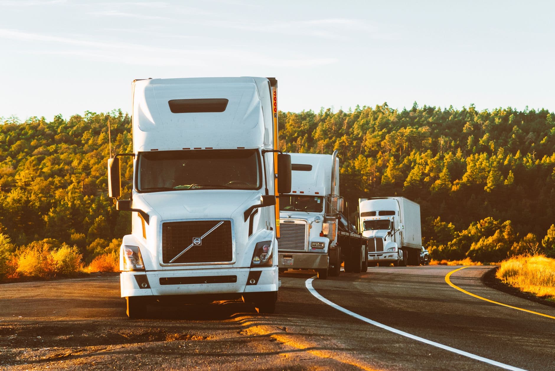 Semi trucks hauling on an open highway.