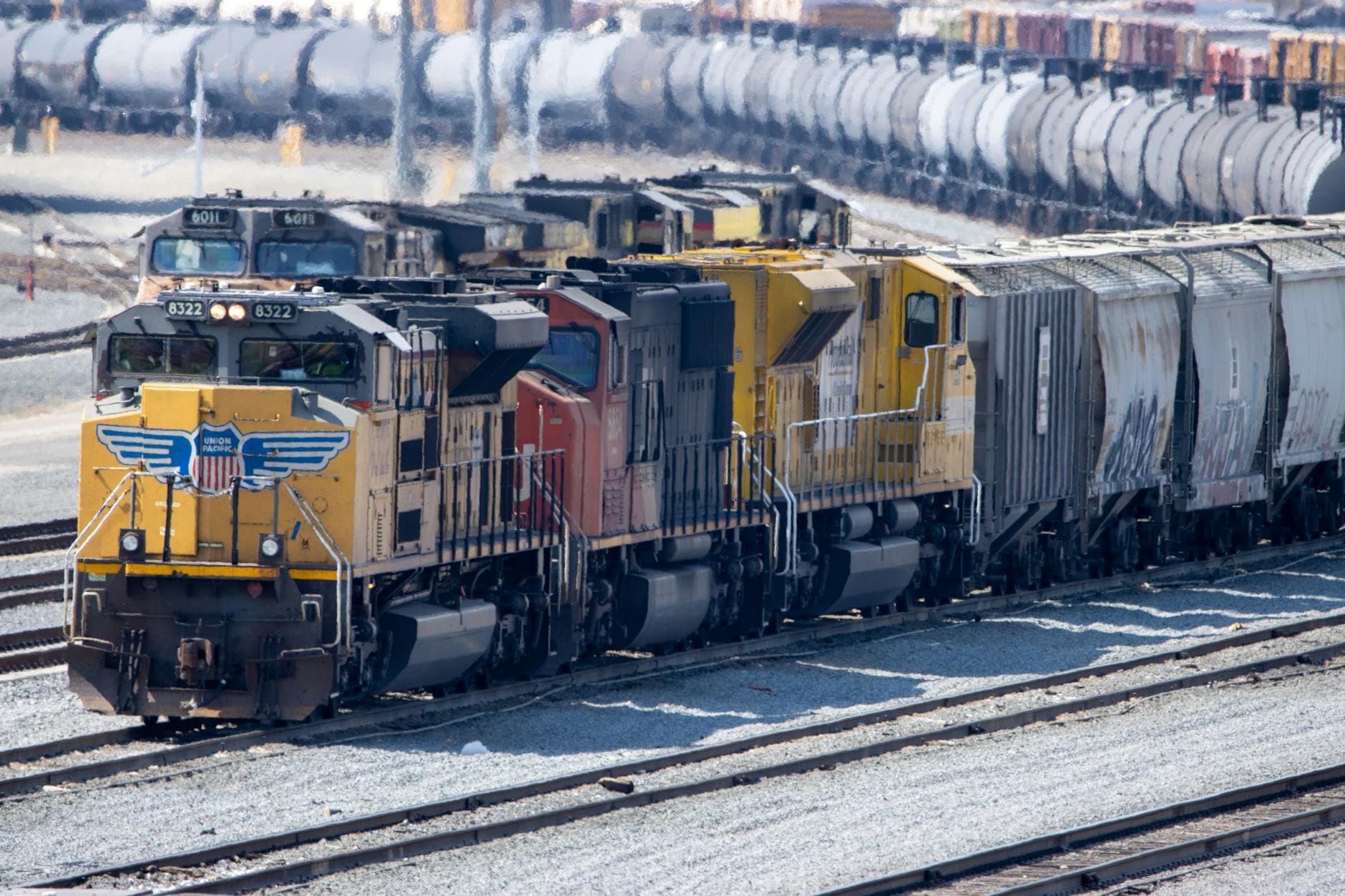 Yellow and gray locomotives in a North American intermodal rail yard.